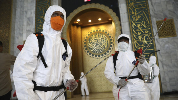 Workers prepare to disinfect al-Akbar mosque in Surabaya, East Java, Indonesia