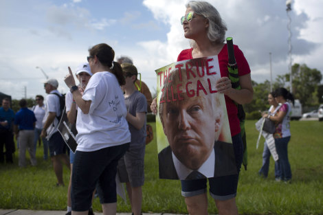 A demonstrator holds a sign during the 'Keep Families Together' rally outside of a temporary shelter for unaccompanied migrant children in Homestead, Florida on Saturday.