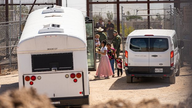On the day Title 42 is set to expire, migrants are directed onto US government buses after crossing through a section of the border wall in El Paso, Texas.