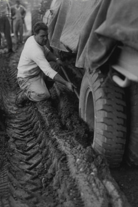 Clearing the mud from one of the trucks bogged down after trying to break the blockade by a back road. July 24, 1956.