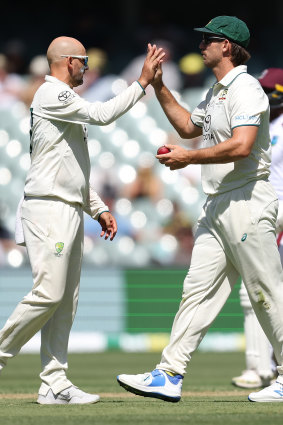 Nathan Lyon and Mitch Marsh celebrate the wicket of Shamar Joseph on day one.