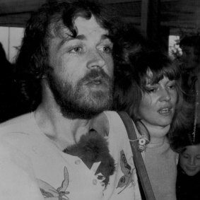 Joe Cocker, with a toy koala stuffed in his shirt, walks with friend, Eileen Webster, 
to the aircraft in Melbourne, 21 October 1972.