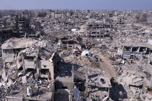 An aerial photograph taken by a drone shows Palestinians walking through the destruction caused by the Israeli air and ground offensive in Jabaliya, Gaza Strip.