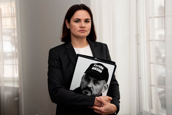 Svetlana Tikhanovskaya com um retrato de seu marido Sergei tirado antes de sua prisão.
