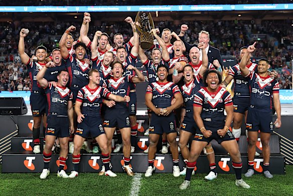 James Tedesco lifts the premiership trophy with the victorious Roosters.