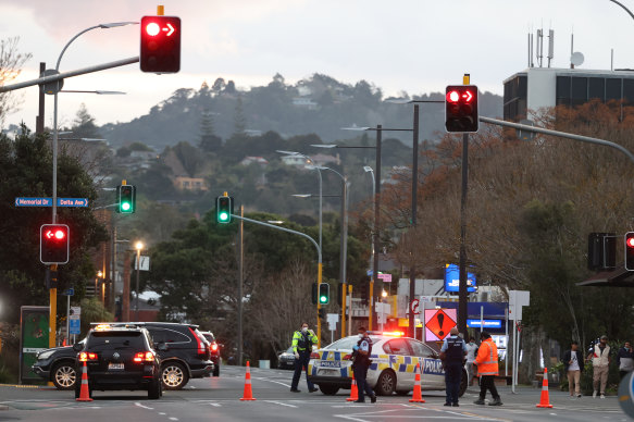 NZ police guard the area around the Countdown LynnMall supermarket after a violent extremist carried out a terrorist attack.