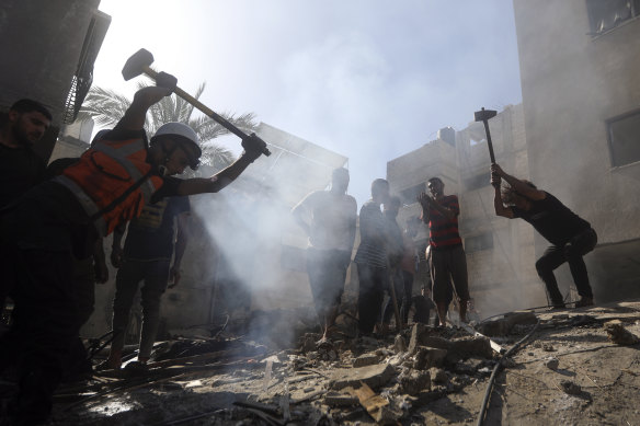 Palestinians look for survivors under the rubble of a destroyed building following an Israeli airstrike.