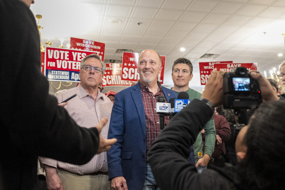 Wisconsin Supreme Court candidate Brad Schimel (in blue jacket) talks to the media after a rally at the American Serb Memorial Hall in Milwaukee.