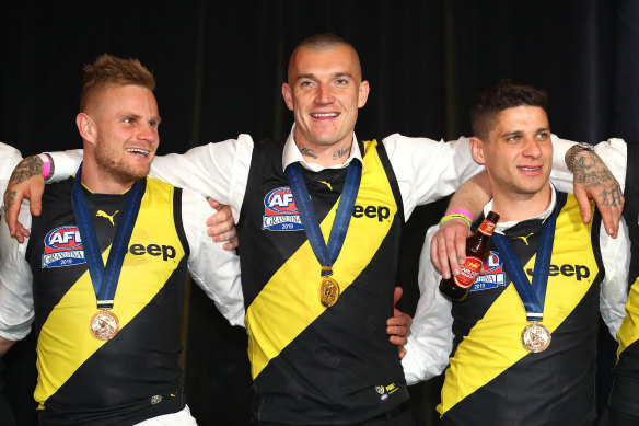 From left: Brandon Ellis, Dustin Martin and Dion Prestia celebrate Richmond’s 2019 flag.