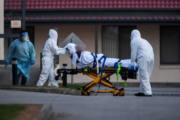 A resident is taken from St Basil's Home for the Aged in Fawkner to hospital on Friday.