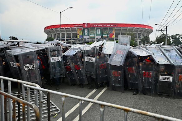 Police officers stand guard outside the Azteca Stadium.