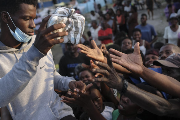 Food bags are handed out to earthquake survivors in Les Cayes.