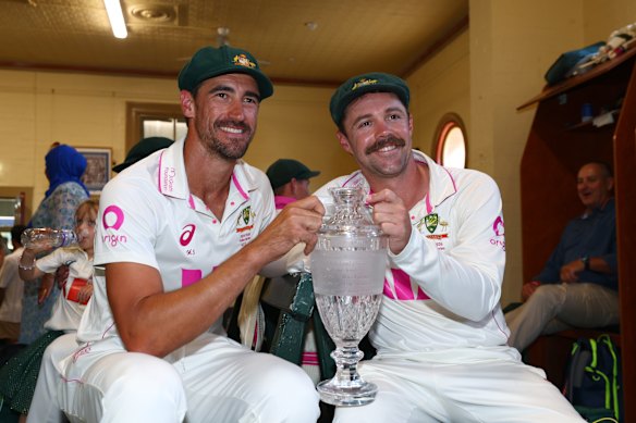 Mitchell Starc and Travis Head with the Ashes trophy.