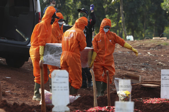 Workers in protective suits carry the coffin of a suspected victim of COVID-19 during a burial at Pondok Ranggon cemetery in Jakarta, Indonesia, earlier this month. 