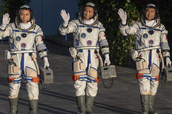 From Left, Chinese astronauts Tang Hongbo, Nie Haisheng and Liu Boming wave before launch of the Senzhou-12 n Jiuquan, Gansu province, on June 17.