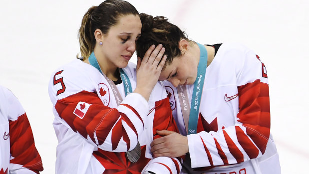 Falling short: Canada's Lauriane Rougeau comforts forward Rebecca Johnston.