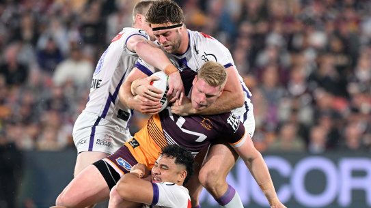 Thomas Flegler of the Broncos is tackled by Storm defenders.