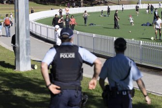 Police patrol at Gore Hill oval today. Many of Sydney’s parks and beaches were packed on a sunny school holiday weekend.