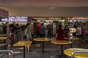 Customers wait for takeaway at a food court in the Bugis area of Singapore. Dining rules are changing next week, with an emphasis on vaccination.