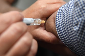 A man receives a flu shot as part of a work-provided flu vaccination initiative in a file picture.