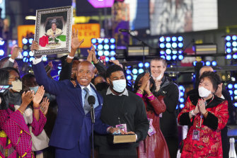 Eric Adams holds up a framed image at his swearing-in as New York mayor at the Times Square New Year’s Eve celebration. 
