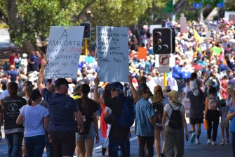 People march through Perth’s CBD holding signs and calling out the word “freedom” in protest of vaccine mandates and strict borders. 