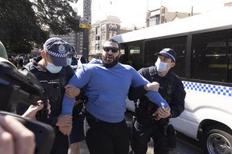 A protester is taken away by NSW Police at Victoria Park, Sydney on Saturday.