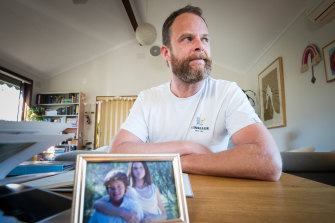 Broder Lackmann with a family photograph of his sister Christina, 32, who died while waiting around six hours for an ambulance.