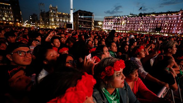 Spectators look on as French-Chilean singer Ana Tijoux performs during a concert by female artists on the eve of International Women's Day, in the Zocalo in Mexico City.