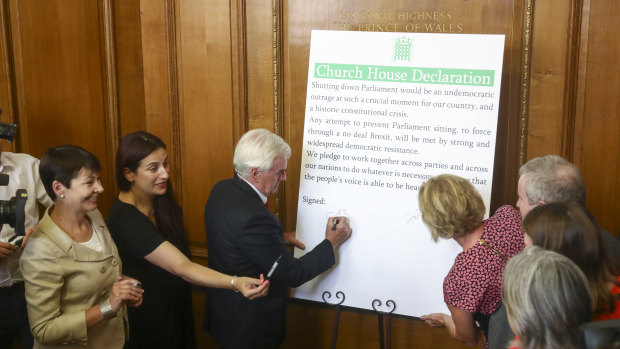 John McDonnell, finance spokesman for the British opposition Labour party, signs a declaration following a cross party meeting of members of parliament to oppose any attempts to prevent Parliament from sitting.