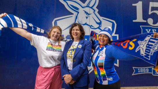 Mega fans Caitlin Latter (left) and Devina Potter with North Melbourne president Sonja Hood.