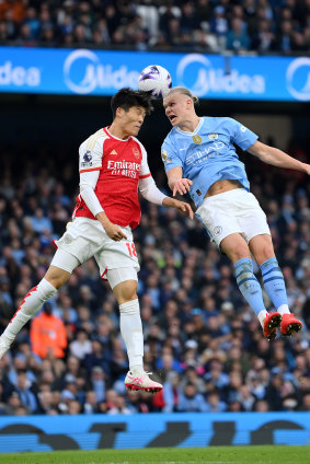 Takehiro Tomiyasu and Erling Haaland compete for a header.