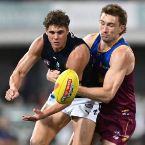 Charlie Curnow handballs while being tackled by Harris Andrews in their preliminary final.