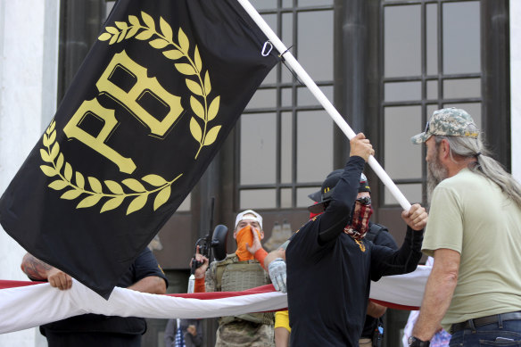 A protester carries a Proud Boys banner in front of the Oregon State Capitol in Salem. 