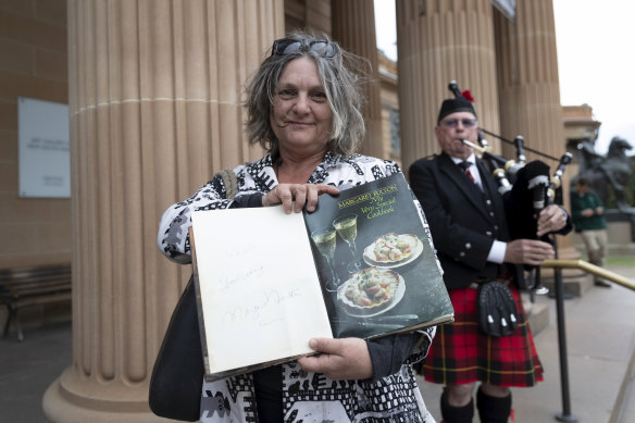Maria Gunnerson-Briggs holds a signed copy of Margaret Fulton's cookbook outside the State Memorial Service for Margaret Fulton at the Art Gallery of NSW.