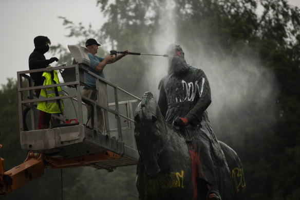 Workers clean graffiti from a statue of Belgium’s King Leopold II in Brussels that was targeted by protesters during a Black Lives Matter demonstration in 2020. 