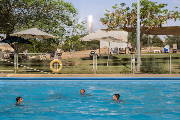 Children swim in a public pool near the solar tower.