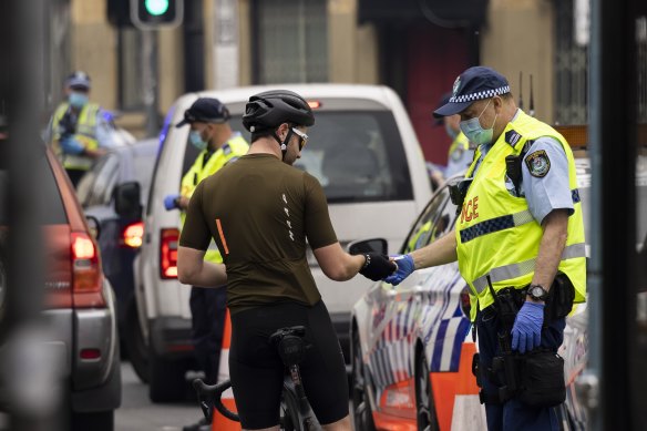 Police check the details of a cyclist at a road block in August 2021.