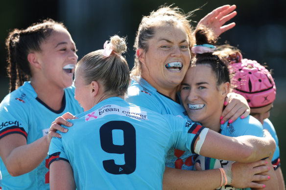 Maya Stewart is congratulated for scoring  try for the Waratahs.