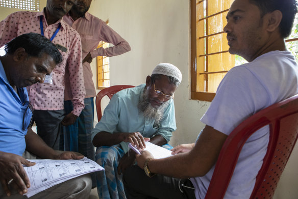 Farid Ali, a farmer (centre), looks in vain for his name on a list of verified citizens, in Shyampur, India. Lists of verified citizens were posted across the Indian state of Assam on Saturday. Those whose names did not appear — most of them Muslims — could soon be stateless. 