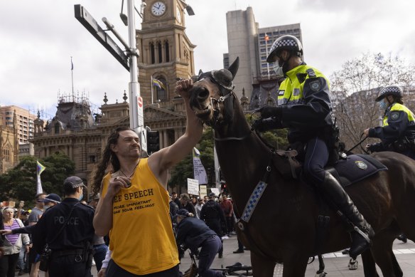 A man makes contact with a police horse during an anti-lockdown rally in the CBD.