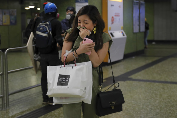A woman emerges from a Hong Kong subway station after police used tear gas underground on Sunday night.