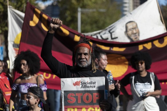 Demonstrators hold signs at a rally on April 10 to protest against Indigenous deaths in custody.