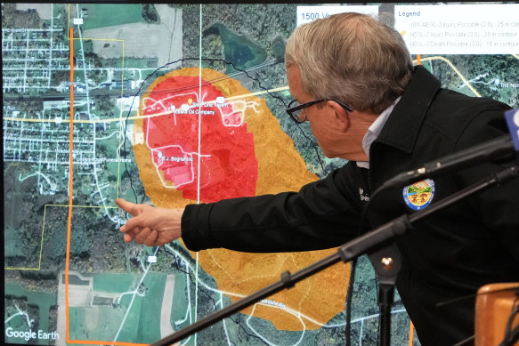 Ohio Governor Mike DeWine points to a map of East Palestine, Ohio that indicates the evacuated area.
