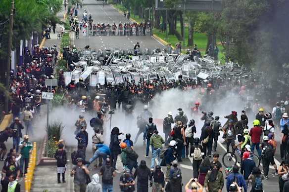 Police officers face off with protesters in Mexico City. Collectives, unions and civil organisations convened a mega protest against the government for the opening day of the World Cup.