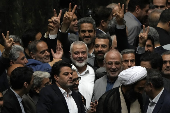 Hamas chief Ismail Haniyeh, centre, flashes a victory sign as he is surrounded by a group of Iranian MPs at the conclusion of the swearing-in ceremony of newly-elected Iranian President Masoud Pezeshkian on Tuesday.