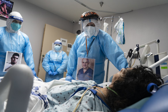 Medical staff wear their photos outside their PPE while checking on a patient at a COVID-19 intensive care unit in Houston, Texas.