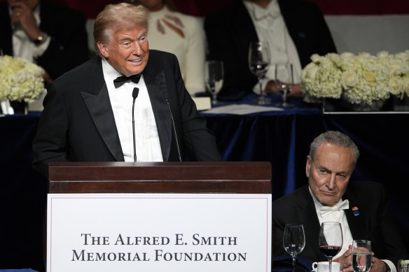 Trump speaks as senator Chuck Schumer listens.