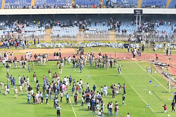 Fans throw chairs and storm on to the field during the Lionel Messi G.O.A.T Tour in Kolkata, India.