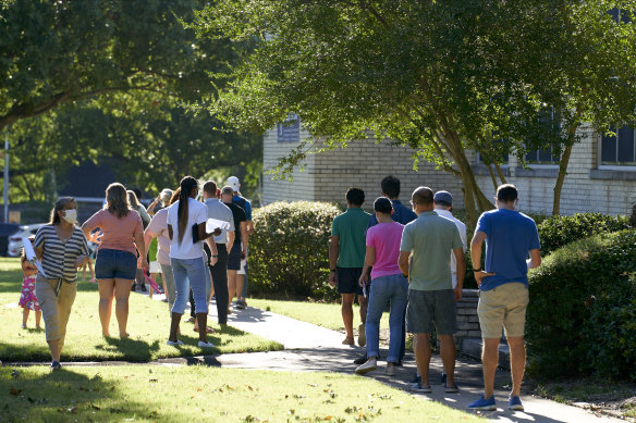 Parents and students queue to pick up electronic devices for remote learning.